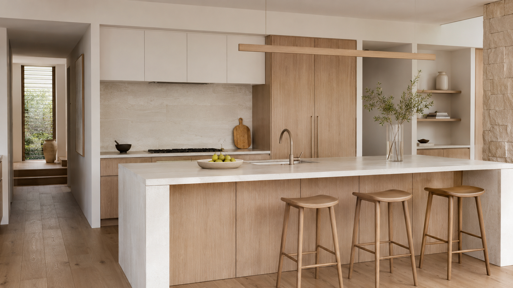 Contemporary kitchen with pale oak joinery, white stone and natural limestone finishes